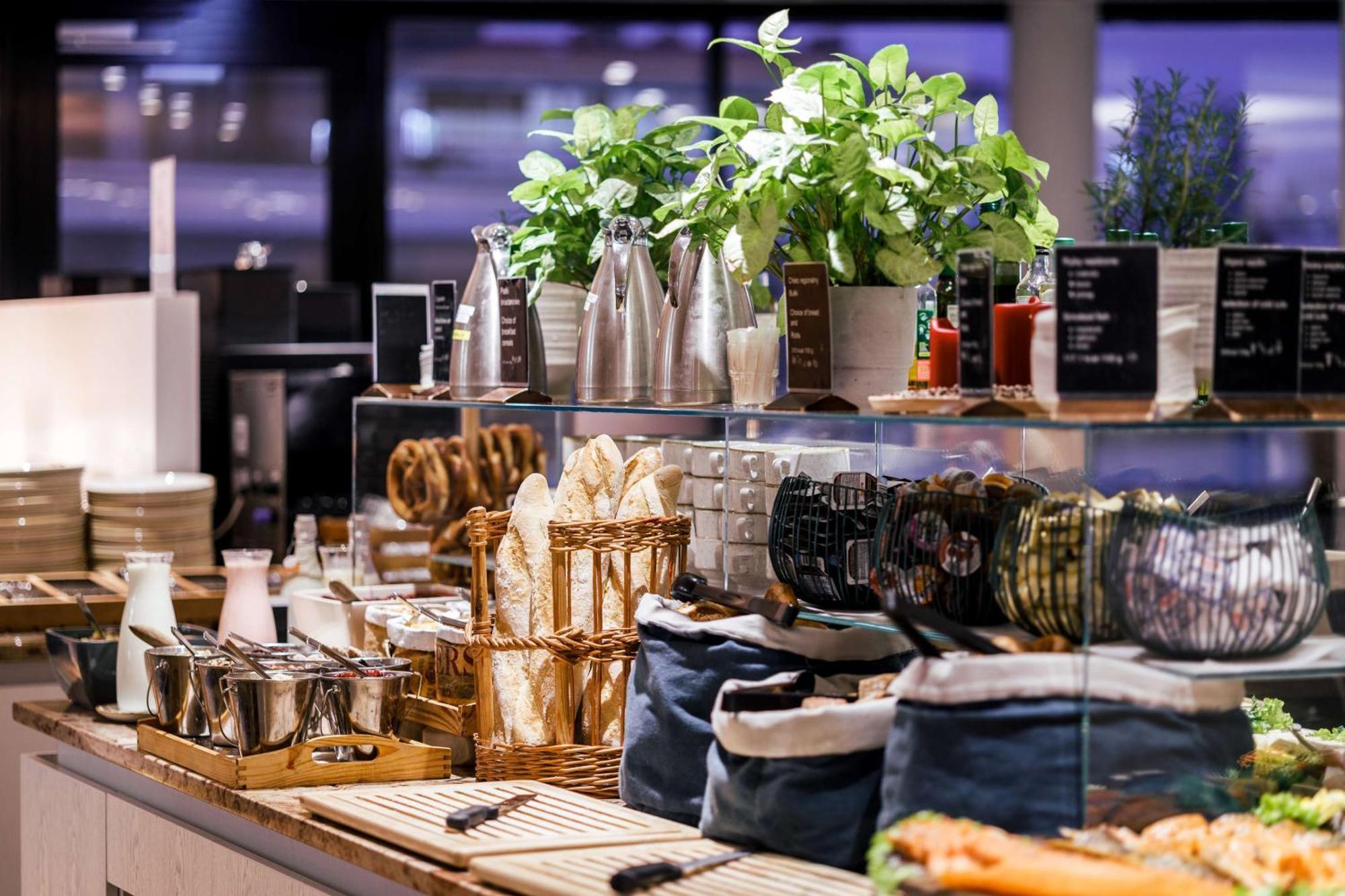 Radisson Blu Resort Świnoujście Εξωτερικό φωτογραφία The photo depicts a beautifully arranged buffet or food display area. It features various items such as:

- Several glass or metal containers, possibly holding beverages or condiments.
- Fresh greenery in pots, suggesting a focus on natural elements.