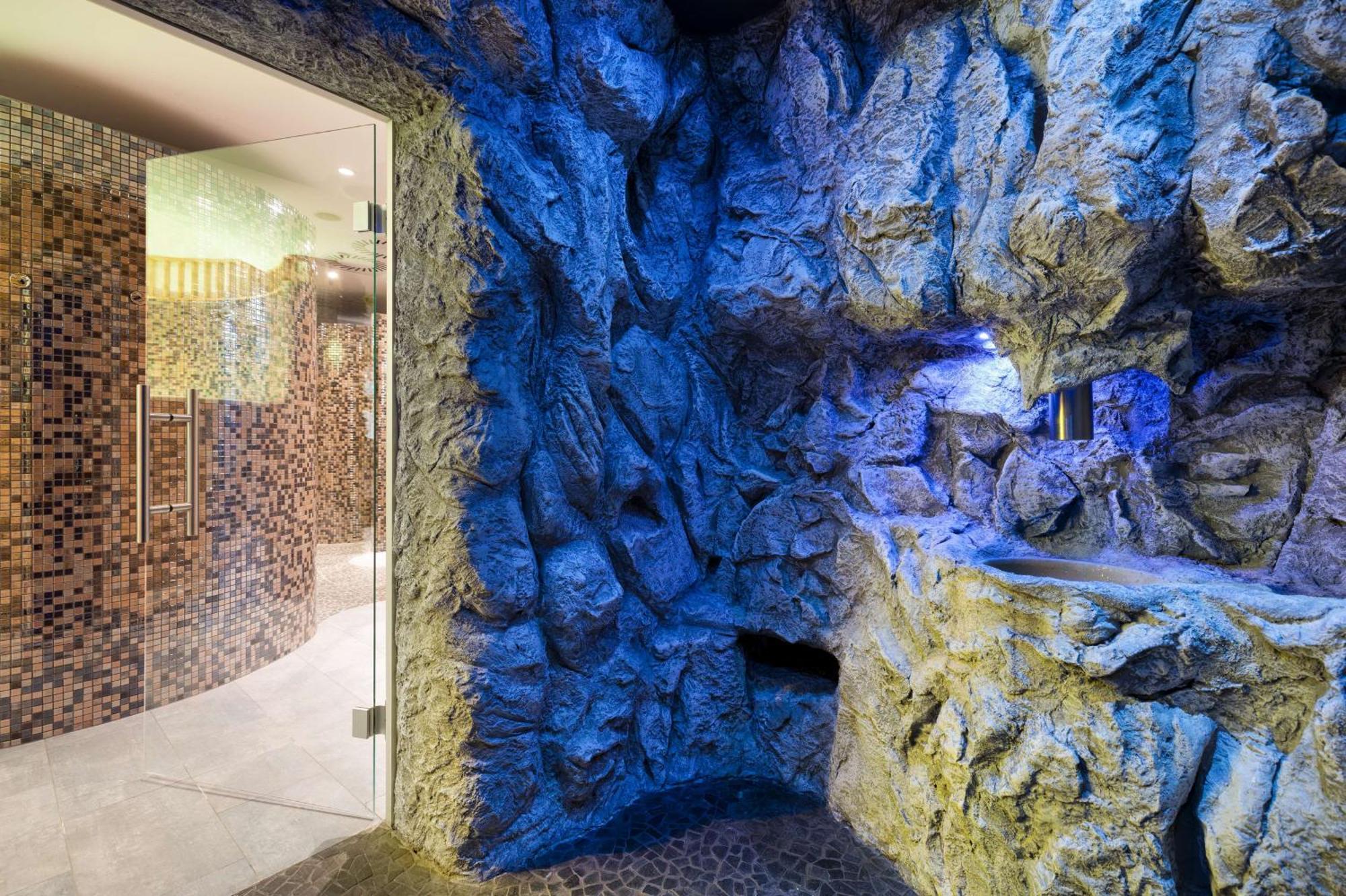 Radisson Blu Resort Świnoujście Εξωτερικό φωτογραφία The photo shows a spa-like environment with a cave-like design. The walls are styled to resemble natural rock formations, featuring textures and colors that suggest a stone surface. Soft blue lighting highlights the contours of the rocks, creating a 